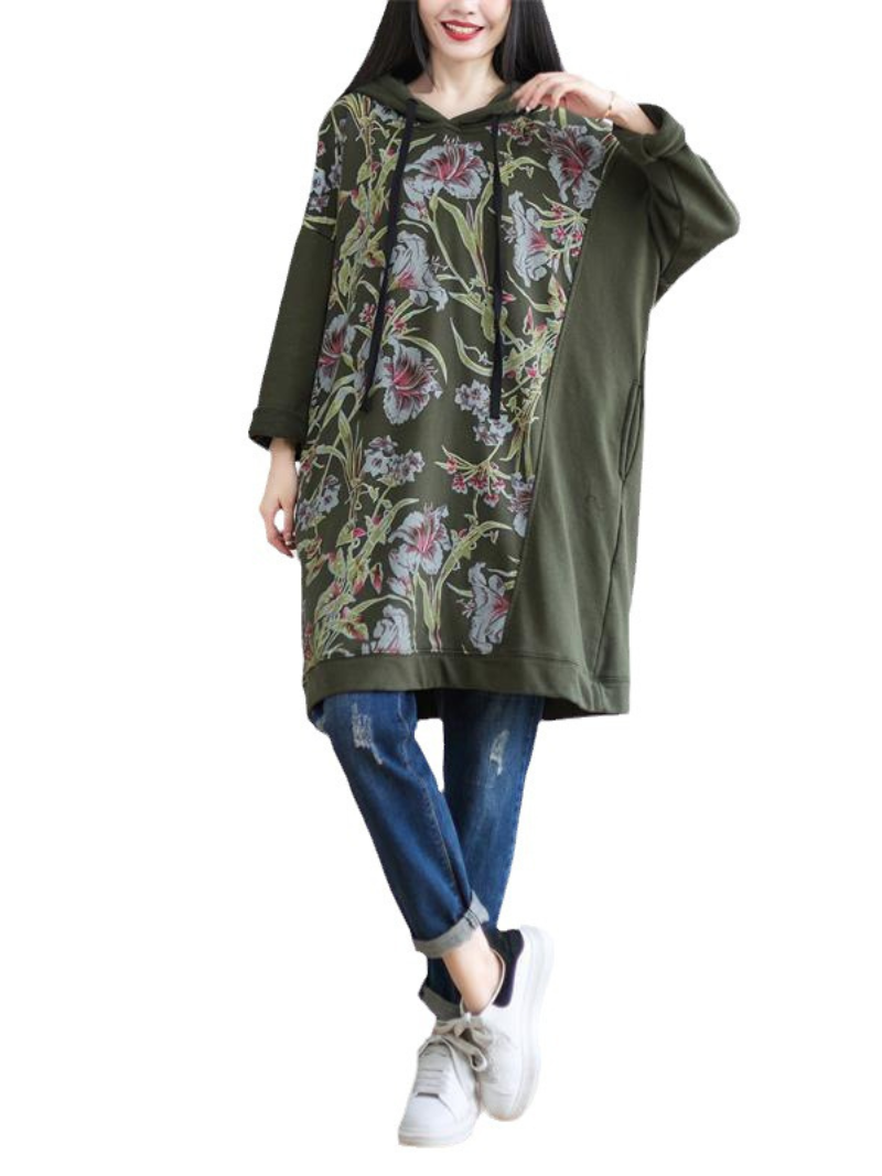 A woman wearing a green hooded mid-length dress 