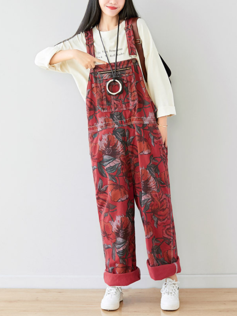 A woman wearing red printed large size overalls dungarees with a mid-rise waist and functional pockets 