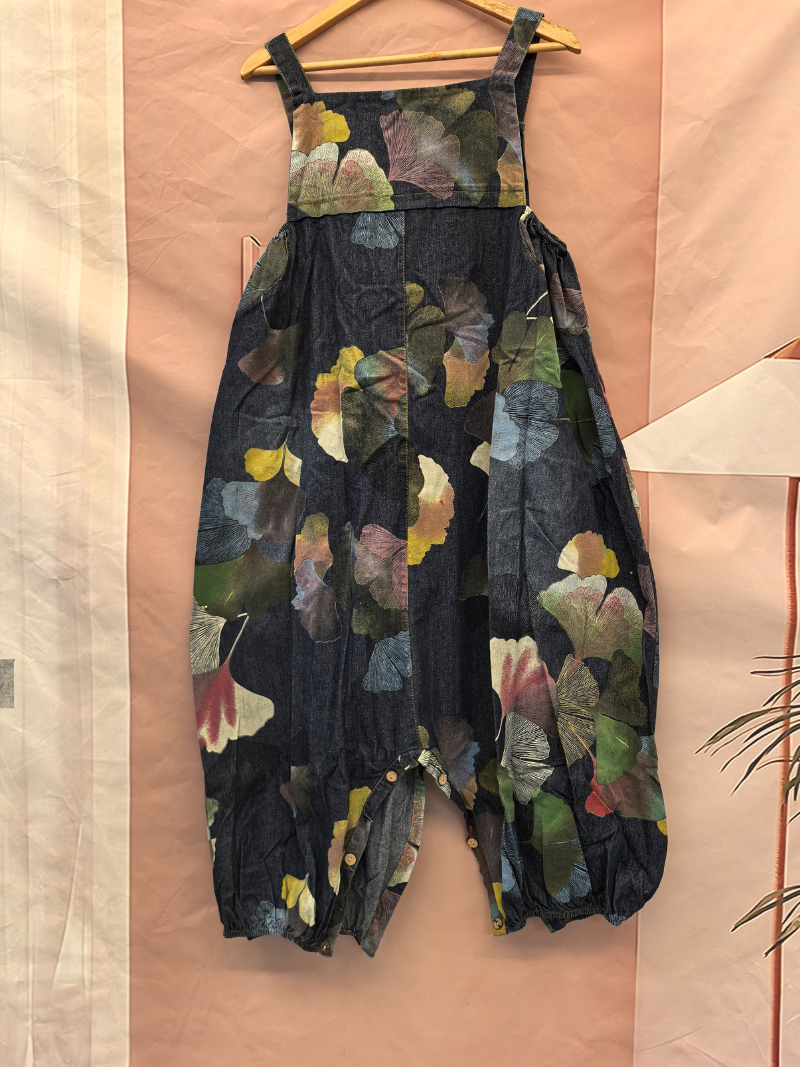 Floral-patterned dress on a hanger against a beige wall