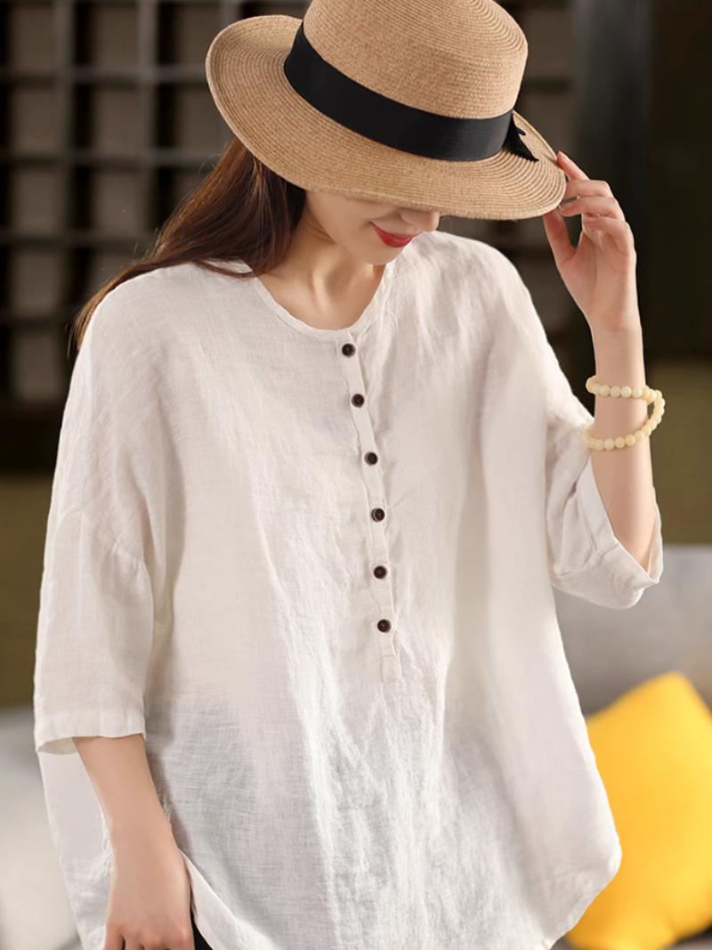 A woman wearing a White  solid color shirt top with a classic crew collar 