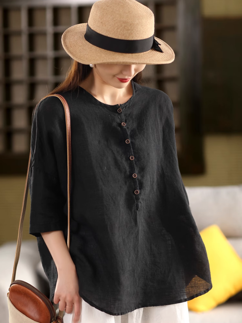 A woman wearing a Black  solid color shirt top with a classic crew collar 