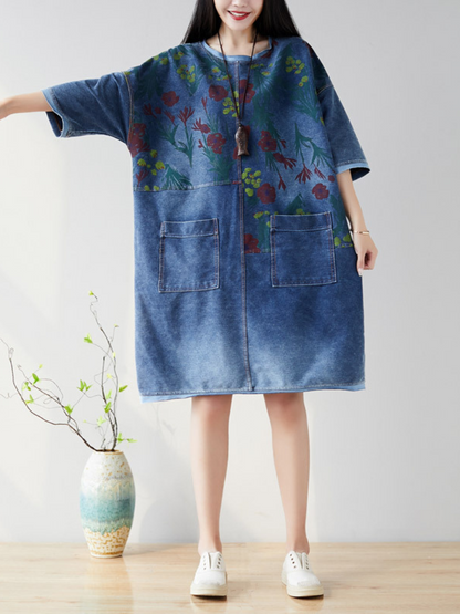 A woman wearing a casual floral midi dress with large pockets, in light blue denim color, 
